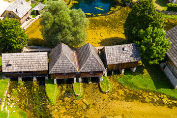 Fototapeta na wymiar Majerovo vrilo river source of Gacka aerial drone view, Lika region countryside of Croatia, old wooden mills and cottages