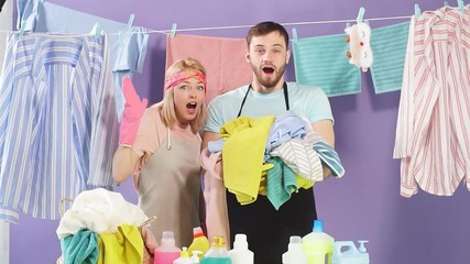 Shocked emotional couple having much work to do being in panic. Emotional and feeling.clean clothes hanging on the clothesline
