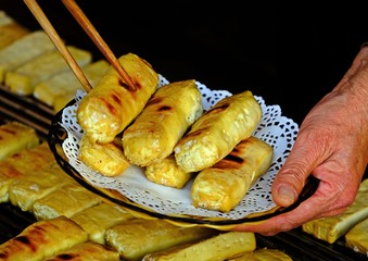 Shot of Chinese grilled tofu being moved from stove to the dish using chopsticks.