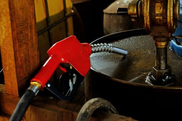 Rural and country-side red gasoline dispenser ready to inject fuel in the tank.