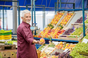 Senior man  buying  at the green market