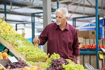 Senior man  buying  at the green market