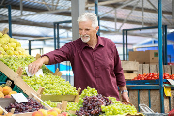 Senior man  buying  at the green market