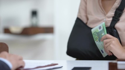 Employer giving female worker in arm sling money compensation for trauma