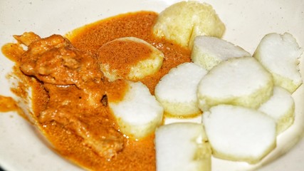 Chicken Rendang. Traditional Indonesian dish served during Eid al Fitr or Idul Fitri. Served with compressed rice cake or lontong. Selected focus. Close up.