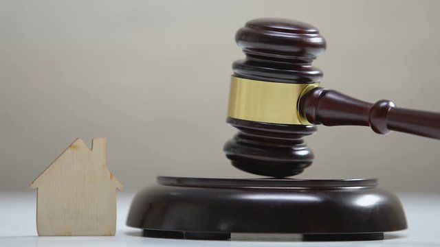 Paper house on table, judge striking gavel, administrative court, inheritance