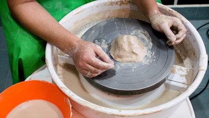 A raw clay pot in the hands of a potter. Workshop in the pottery workshop