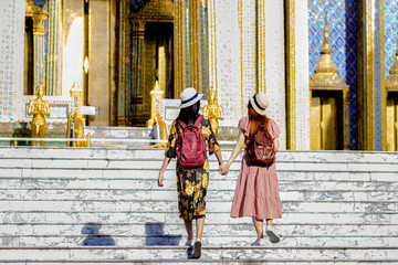 Naklejka premium young tourist woman walking through the palace temple in Bangkok of Thailand Emerald Buddha Temple, Wat Phra Kaew, Bangkok Royal Palace popular tourist place