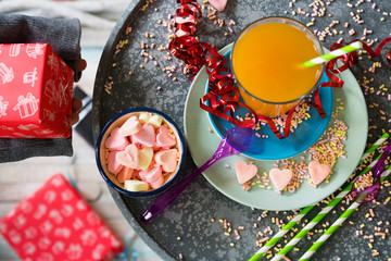 flat lay of birthday party scene with drink, ribbon, candy, presents