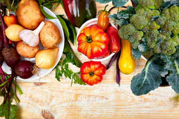 Obraz na płótnie Canvas Fresh colorful organic vegetables from above. Top view, flat lay. Different vegetables for eating healthy on wooden background. Clean eating food frame. Copy space. Vegetarian, vegan..