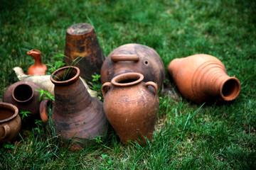 Old clay jars in the garden. Brown ceramic jugs. 