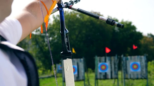 Person shoots a bow at a targer.