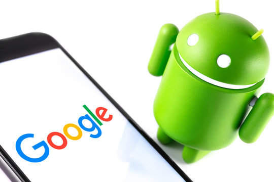Google Android figure and smartphone with Google logo. Google Android is the operating system for smartphones, tablet computers and other devices. Moscow, Russia - March 17, 2019