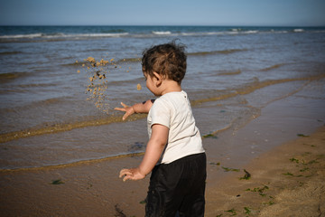 Fototapeta na wymiar jeune enfant en train de jouer au bord de mer