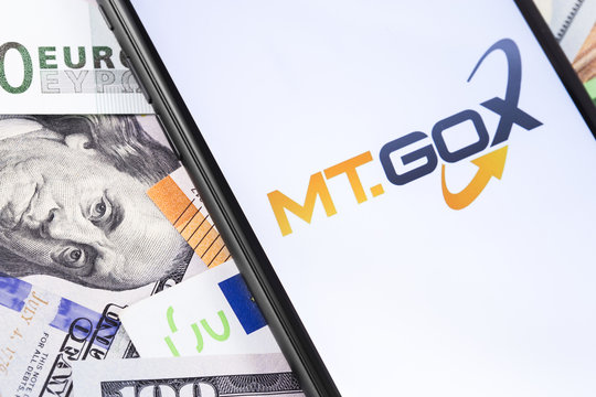 money and MT.GOX logo of exchange on the screen smartphone. MT.GOX is popular largest cryptocurrency exchange on the market. Moscow, Russia - February 13, 2019