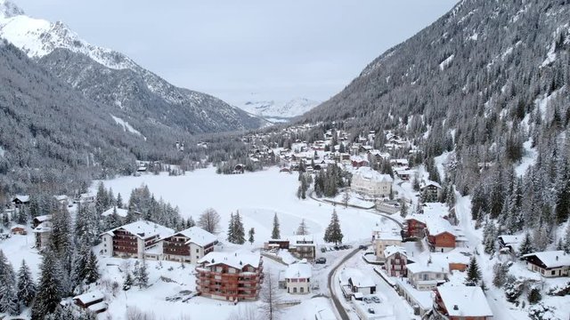 4K Christmas winter holidays in the mountains aerial shot. Lovely ski resort in a frozen landscape
