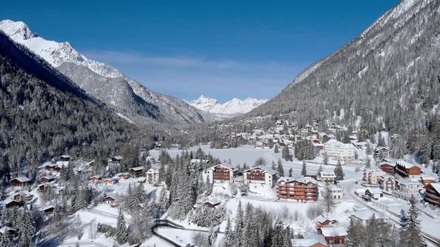 4K Ski resort the the Alps Switzerland aerial shot. Cinematic drone shot on a sunny morning with fresh snow on the trees