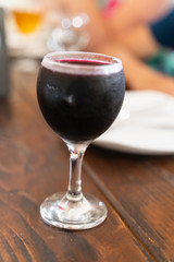 a glass of red wine on a wooden table with selective focus and soft background blur.
