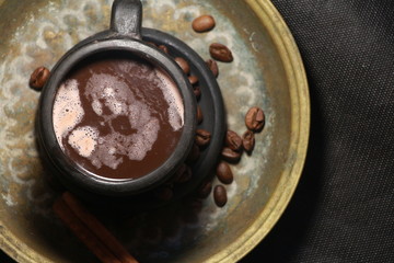 coffee beans and cinnamon stick on a dark background