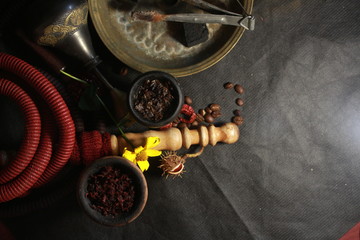bowl with tobacco for hookah. red pomegranate on a black background. smoking nargile