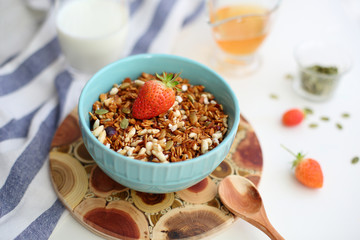 granola with strawberries in a plate on a white table