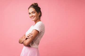 Image of positive beautiful woman wearing striped clothes smiling at camera and standing with arms crossed