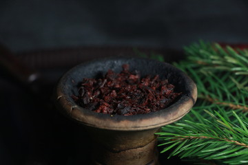 bowl with tobacco for hookah. berries on a black background