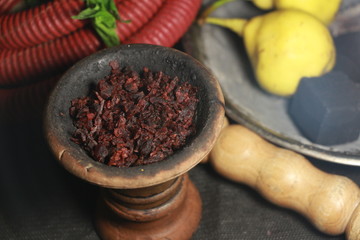 bowl with tobacco for hookah. berries on a black background