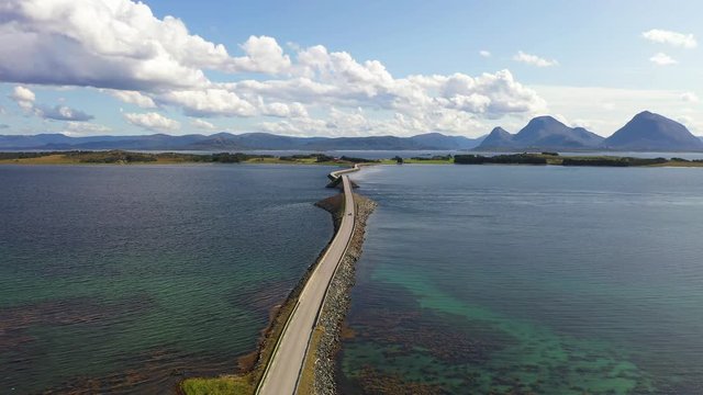 Aerial drone push in shot as flying straight forward over a highway built on ocean, island to island transportation.