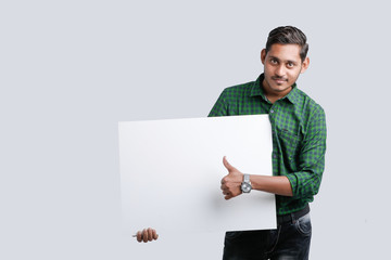 young indian guy holding blank poster