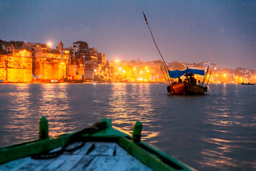 People on the boat floating on the river are going to pray at Varanasi Ganga Aarti at holy...