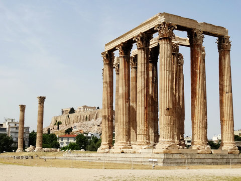 Temple of Olympian Zeus in Athens in Greece with The Parthenon Temple on hill in sight.  Temple of Olympian is also known as the Columns of the Olympian Zeus.