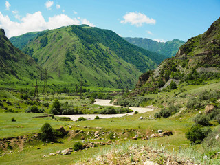 Fototapeta na wymiar beautiful mountain landscape with a river flowing across the plain on a Sunny summer day