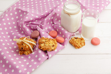 Milk glass and biscuit cookies with kitchen cloth on light background