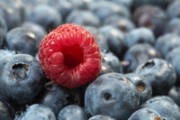 Fresh ripe raspberry and a bunch of blueberries