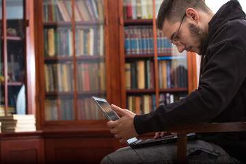 Student is working for exams on laptop in classroom