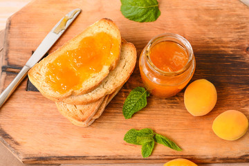 Toasted bread with apricot jam on wooden board