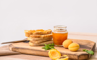 Toasted bread with apricot jam on wooden board