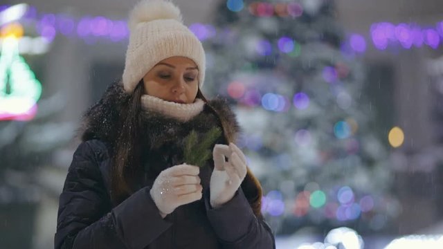 portrait of a young woman near the Christmas tree in the winter evening on the square