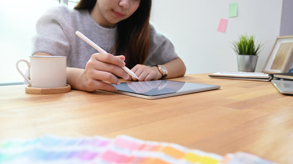 Young creative woman using pen select colour in graphic designer job.