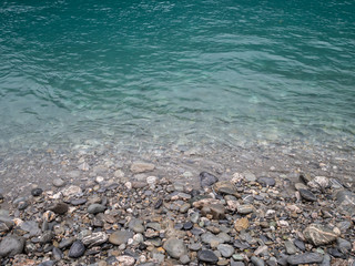 View of turquoise blue creek and stony shore