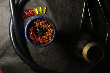 bowl with tobacco for hookah. berries on a black background 