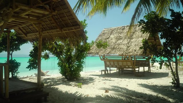 Bungalow on a tropical beach with palm trees and blue sea of Daco, Philippines. Summer and travel vacation concept