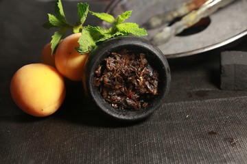 bowl with tobacco for hookah. fruits on a dark background. smoking shisha
