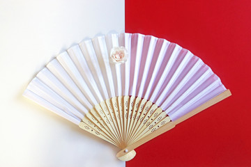 white hand fan with a rose