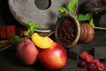 bowl with tobacco for hookah. berries on a black background