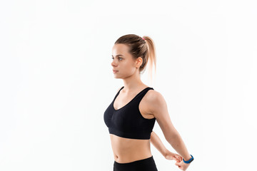 Fototapeta premium Young sporty blond woman in a black sportswear stretching before exercising isolated over white background.
