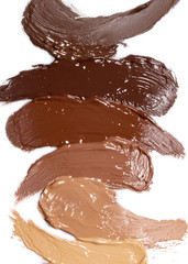Deckende cremige Kosmetik, Foundation in dunklem Braun, in braun mit rotem Unterton, in Rotbraun, in dunklem Beige mit rotem Unterton in Beige, in Beige mit gelbem Unterton auf weissem Hintergrund