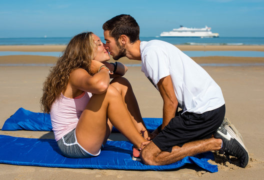 young couple in love doing pilate on the sunny beach