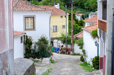 Typical old village street with little houses and orange roofs in Portugal